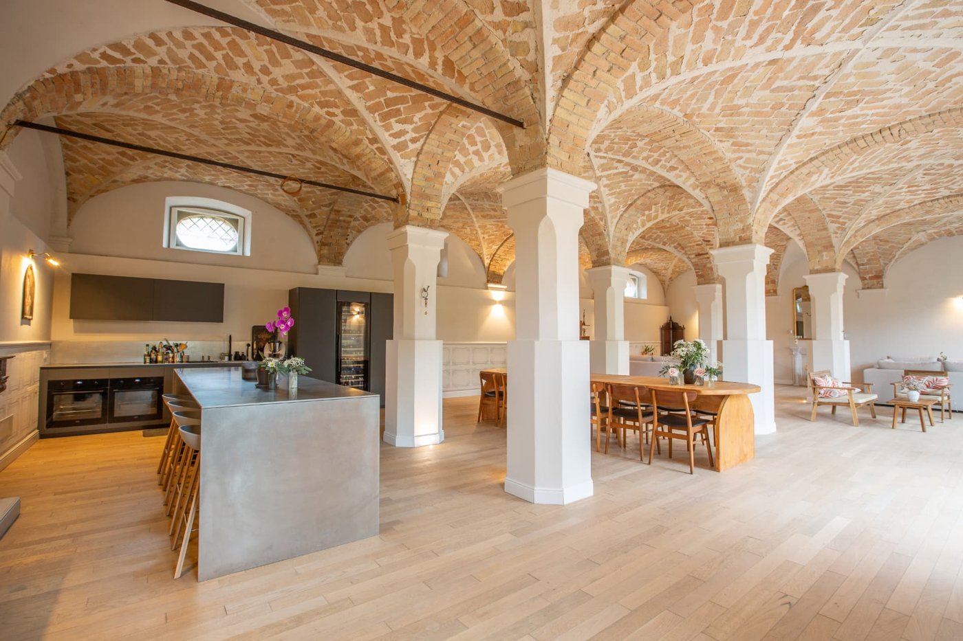 The cooking room at Retreat Monferrato, with a long table and an open kitchen